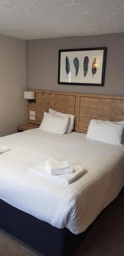 a large white bed in a hotel room at Waterloo Cross, Devon by Marston's Inns in Uffculme