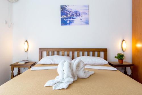 Guest House Mandarina في بودفا: غرفة نوم بسريرين عليها مناشف بيضاء