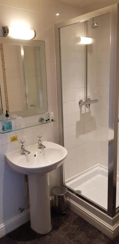 a bathroom with a sink and a shower and a tub at Waterloo Cross, Devon by Marston's Inns in Uffculme