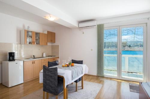 a kitchen and a dining room with a table and chairs at Apartments Barbir in Ploče