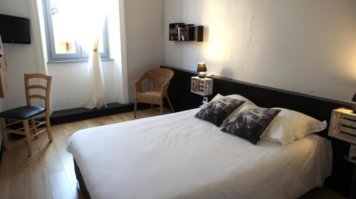 a bedroom with a white bed with two pillows at Hotel des Alpes in Die