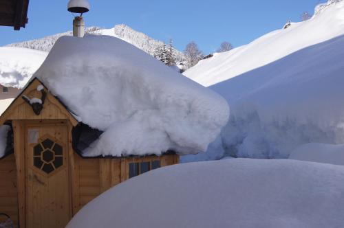 a snow covered house with a pile of snow on it at Alpinchalet Eder - Steiner in Saalbach-Hinterglemm