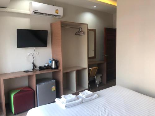 a hotel room with a bed and a tv at Oun Residence in Hat Yai