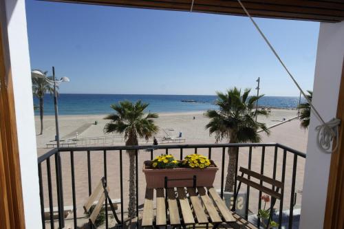 a balcony with a table with a basket of flowers on the beach at AR2B, coqueto apartamento en primera línea de playa in Villajoyosa