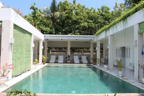 a swimming pool in the middle of a building at Villa Putih Lovina in Lovina