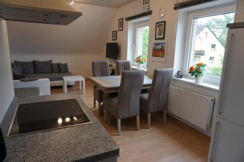 a kitchen and living room with a table and chairs at Lilis Ferienwohnung in Munster im Heidekreis