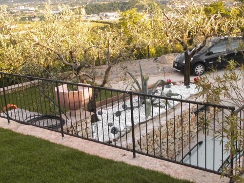 a black metal fence in a yard with trees at B&B Al Cristo in SantʼAmbrogio di Valpolicella