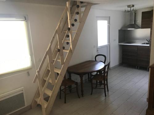 - un escalier en bois dans une cuisine avec une table et une salle à manger dans l'établissement Accès direct mer. Plage du Débarquement, à Ouistreham