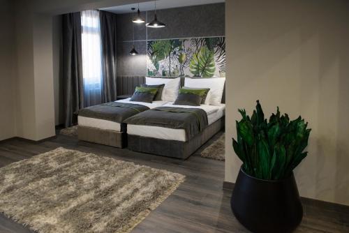 ein Schlafzimmer mit einem Bett und eine Vase mit einer Pflanze in der Unterkunft Hotel Central in Kecskemét