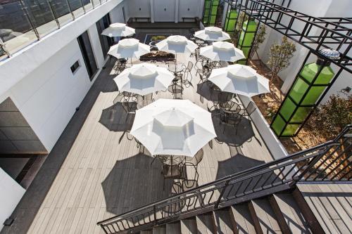 an overhead view of tables with umbrellas on a balcony at Notte La Mia Hotel in Busan