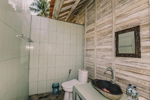 a bathroom with a sink and a toilet in it at The Bridge Huts in Nusa Lembongan