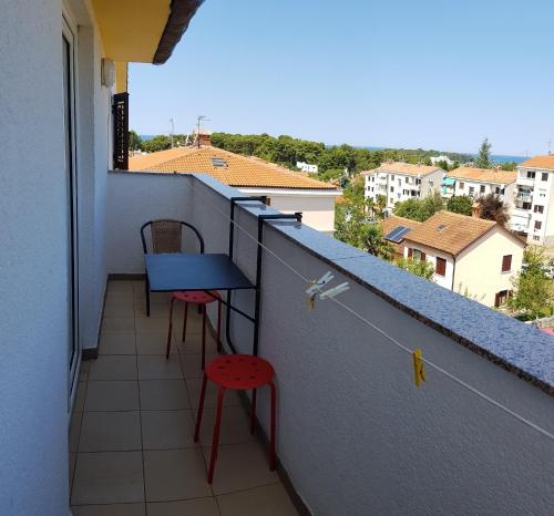 a balcony with a blue table and two chairs at Apartments Lori in Poreč