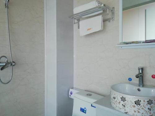 a white bathroom with a sink and a toilet at One Meter Sunshine Xi'an Xianyang International Airport Hotel in Xianyang