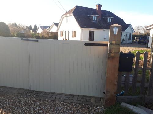 a white fence with a wooden gate in front of a house at The Annexe, Mockbeggar in Ringwood