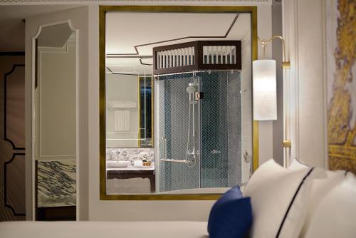 a mirror in a room with a bathroom at Mövenpick Myth Hotel Patong Phuket in Patong Beach