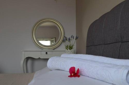 a bedroom with a white bed with a mirror at Romanza Studios in Asos