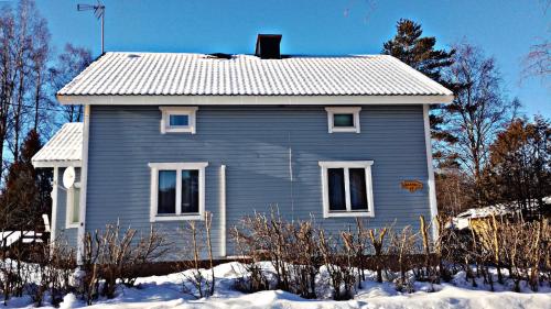 a gray house with a white roof in the snow at K-Vizit Imatra in Imatra