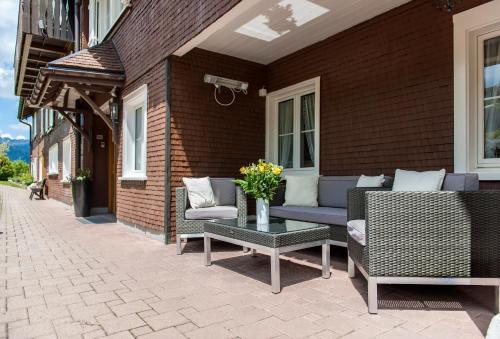a patio with chairs and a table with flowers on it at Schwendi Lodge in Unterwasser