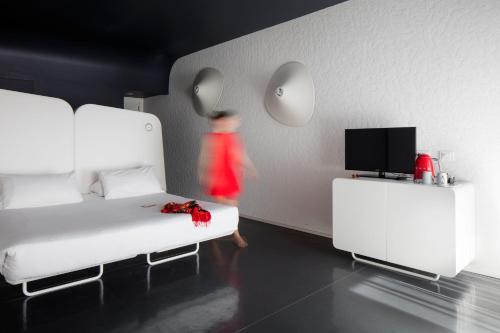 a person in a room with two beds and a tv at Hotel Ripa Roma in Rome