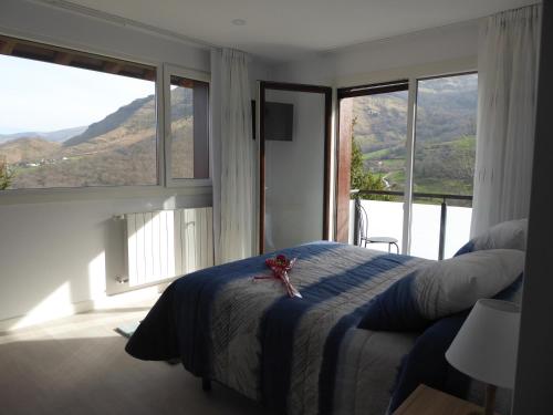 a bedroom with a bed with a teddy bear sitting on it at Balcón de la Len in Quintana de Soba