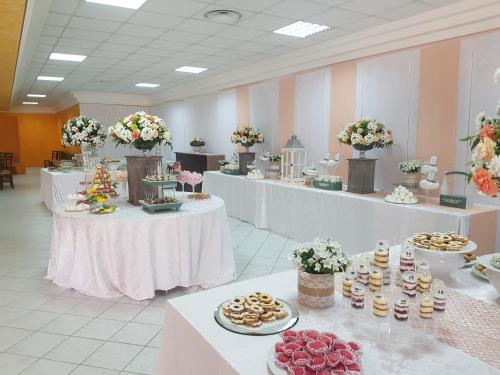 a large room with tables with food and flowers at Le Tre Rose in Bono