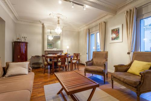 un salon avec une table et des chaises dans l'établissement Greeter-Appartement Haussmannien avec balcon, à Paris