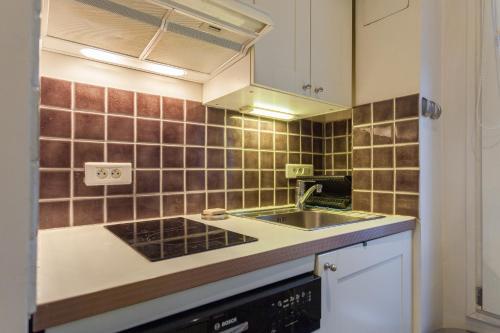 une cuisine avec un évier et un plan de travail dans l'établissement Greeter-Appartement Haussmannien avec balcon, à Paris