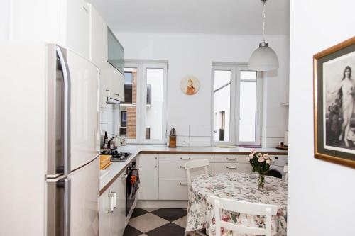 ワルシャワにあるŚrodkowa 30 - studio by Homeprimeの白いキッチン(テーブル、冷蔵庫付)