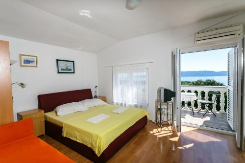 a bedroom with a bed and a balcony at Apartments Posavec in Pinezici
