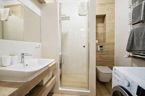 a bathroom with a sink and a shower at Grand Apartments - Neptun Park Smile&Relax in Gdańsk