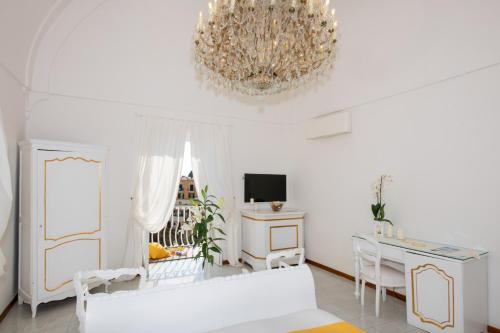 a living room with a white couch and a chandelier at Villa Yiara in Positano