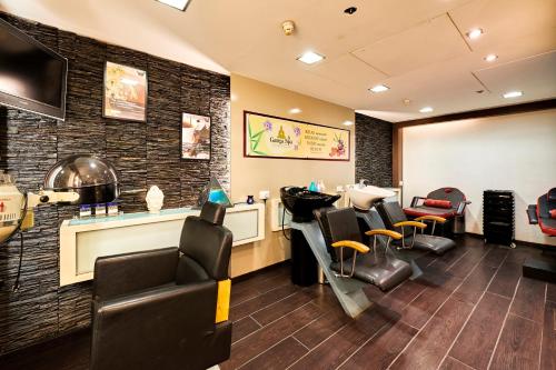 a waiting room with chairs and a barber shop at The Ummed Ahmedabad Airport in Ahmedabad