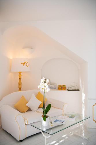 a living room with a white couch and a glass table at Villa Yiara in Positano