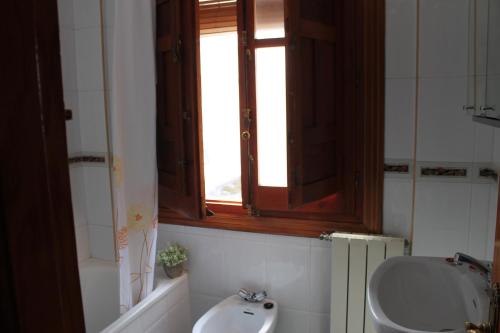 ein Bad mit einem Waschbecken, einem WC und einem Fenster in der Unterkunft Apartamentos Rurales Rosendo: "Flor de Lys" in Capileira