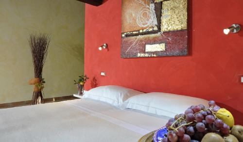 a bedroom with a bed with a red wall at Agriturismo Il Bagolaro in Nerola