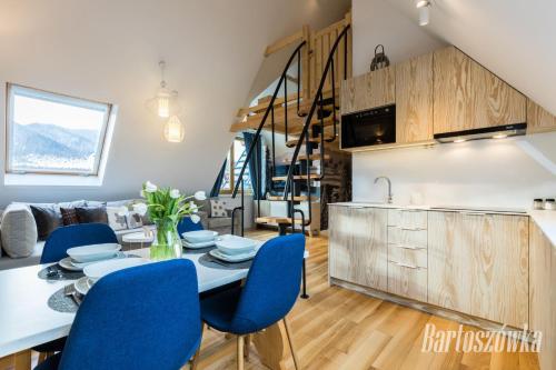 a kitchen and dining room with a table and blue chairs at Rezydencja Zakopiańska in Zakopane