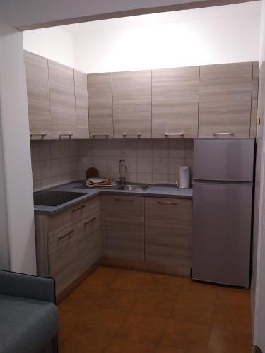 a kitchen with wooden cabinets and a stainless steel refrigerator at Residence Aurora Wellness & Spa in Albenga