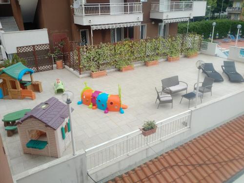 a backyard with a playground with chairs and a house at Residence Aurora Wellness & Spa in Albenga
