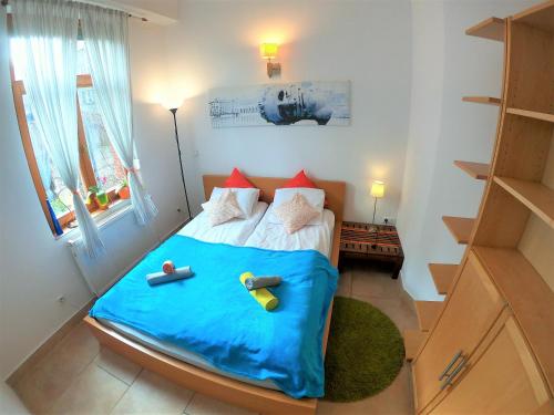 Dormitorio pequeño con cama con manta azul en Homely Apartment's Old Town en Cracovia
