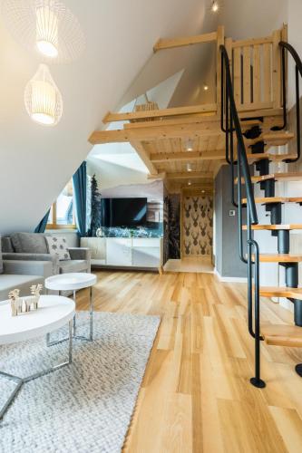 a living room with a staircase in a loft at Rezydencja Zakopiańska in Zakopane