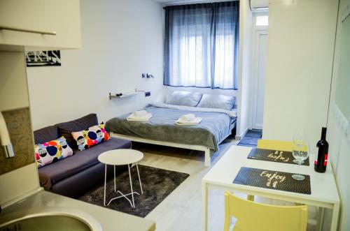 Habitación pequeña con cama y sofá en Studio Apartment Lukas en Vinkovci
