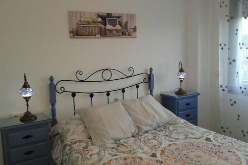 Un dormitorio con una cama con dos mesitas de noche y dos lámparas. en Playa Mar, en Torre del Mar