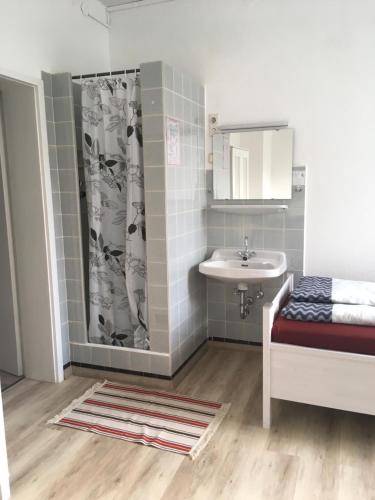 ein kleines Bad mit einem Waschbecken und einer Dusche in der Unterkunft Pension Highway 3 in Bielefeld