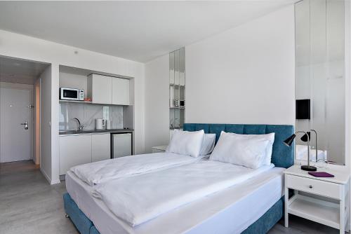 a bedroom with a large bed with a blue headboard at Netanya SeaView ApartHotel in Netanya