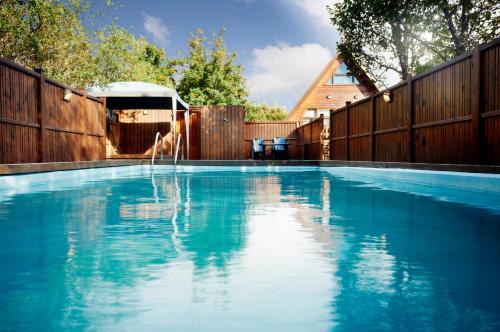- une piscine dans un jardin avec une clôture en bois dans l'établissement Birkihof Lodge, à Laugarvatn
