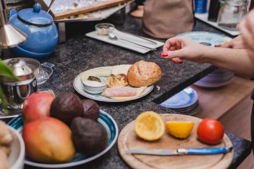 a person reaching for a plate of food on a counter at ALPENHOTEL TYROL - B&B - ADULTS ONLY - Alpines Lifestyle-Konzepthotel - dog friendly in Pertisau
