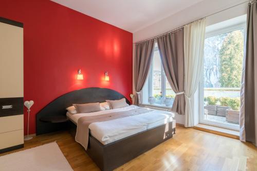 a bedroom with a large bed in a red wall at Kúria Beckov - Penzión in Beckov