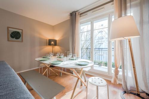 une salle à manger avec une table et une grande fenêtre dans l'établissement Standing apartment in Disneyland BMYGUEST, à Serris