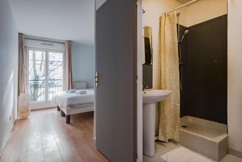 1 cama y baño con lavabo y ducha. en Standing apartment in Disneyland BMYGUEST, en Serris