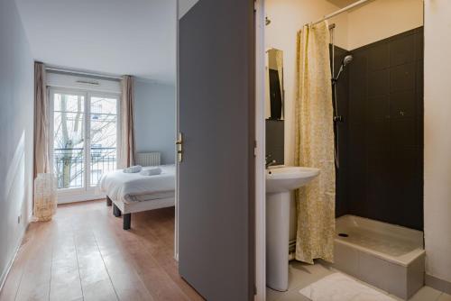 une salle de bain avec un lavabo et une douche et un lit dans l'établissement Standing apartment in Disneyland BMYGUEST, à Serris